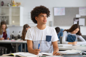 young person looking thoughtful in classroom