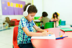 Preschool boy in classroom with headphones on