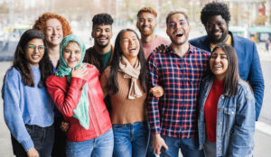 group of teenagers of different ages and ethnicities smiling at camera