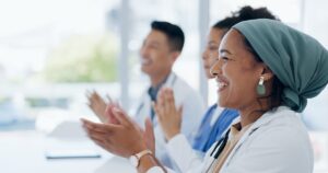group of people clapping at a workshop event for healthcare proffessionals