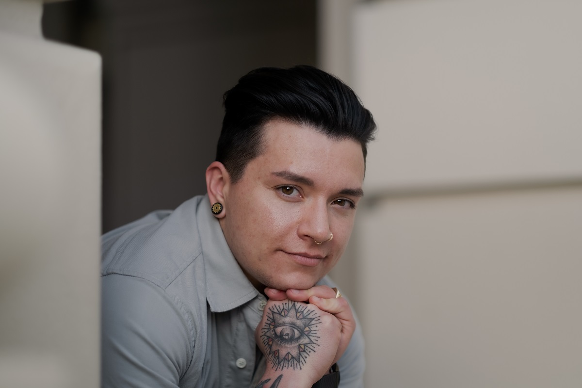 Young non-binary person with a visible hand tattoo