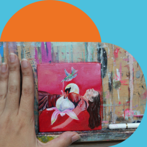 A hand rests beside a small painting of a woman lying on her back with a swan, a flower, and a hummingbird above he